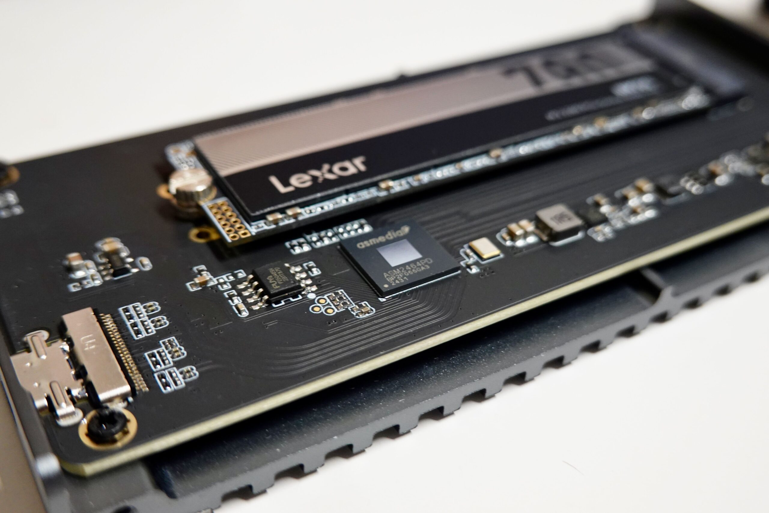 Detalle técnico de un SSD NVMe y su controlador electrónico, representando la capa física donde reside el firmware de gestión.