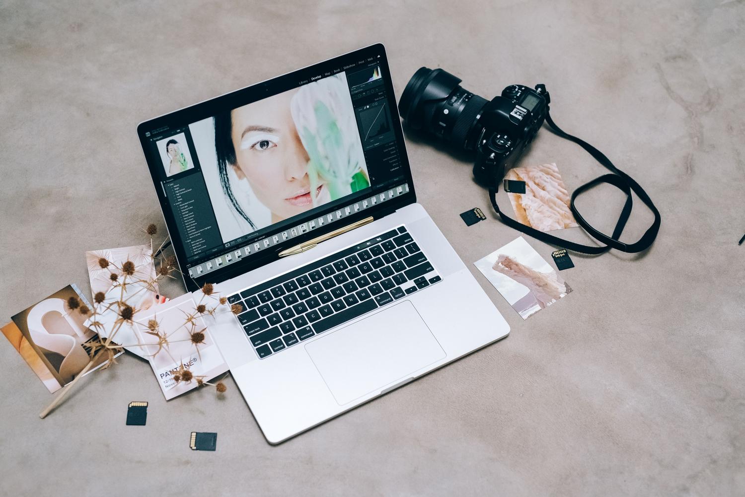 Espacio de trabajo de fotografía profesional con portátil y cámara DSLR para edición de imágenes en alta resolución.