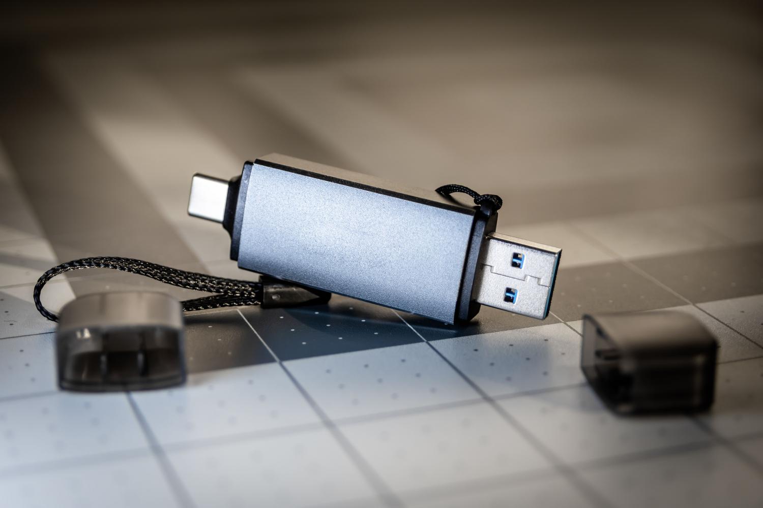 Primer plano de un pendrive USB moderno con conectores duales USB-A y USB-C.