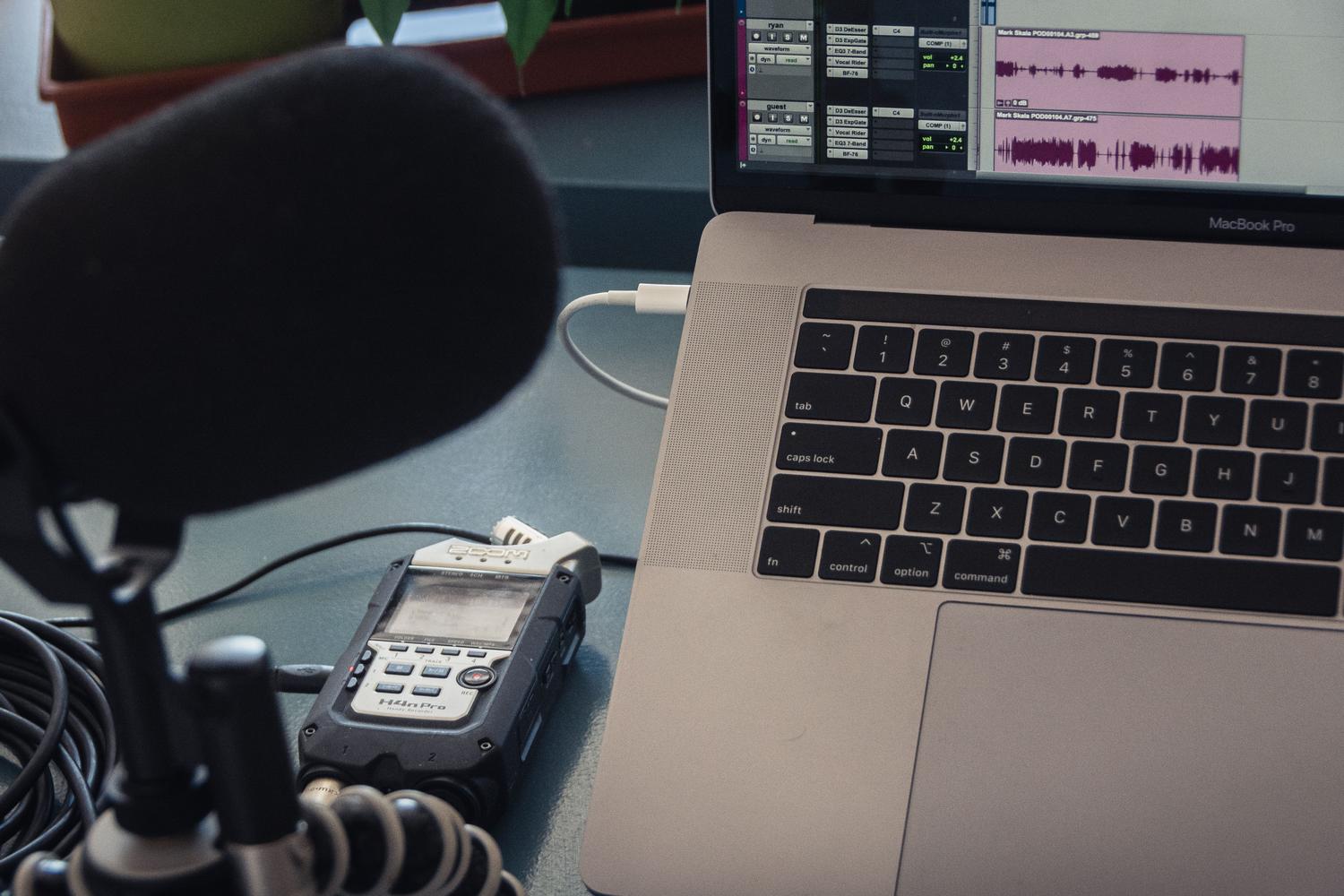Configuración de estudio casero con micrófono y portátil para grabación de audio.