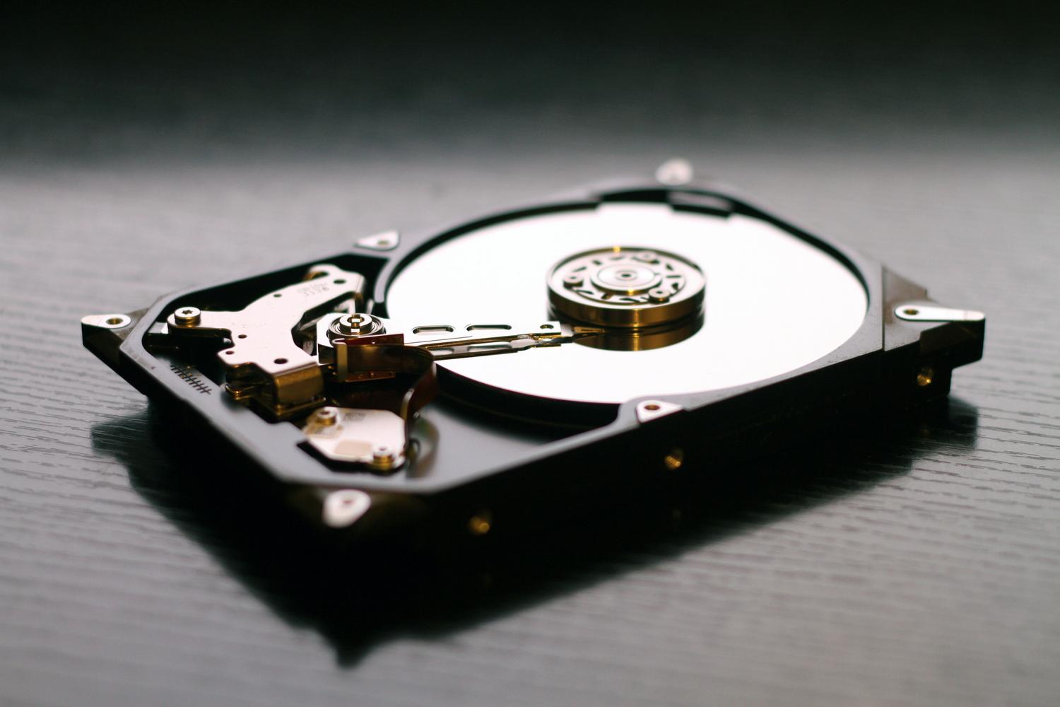 Vista interior de un disco duro mecánico abierto, ilustrando la fragilidad del hardware y la importancia de tener imágenes de sistema.