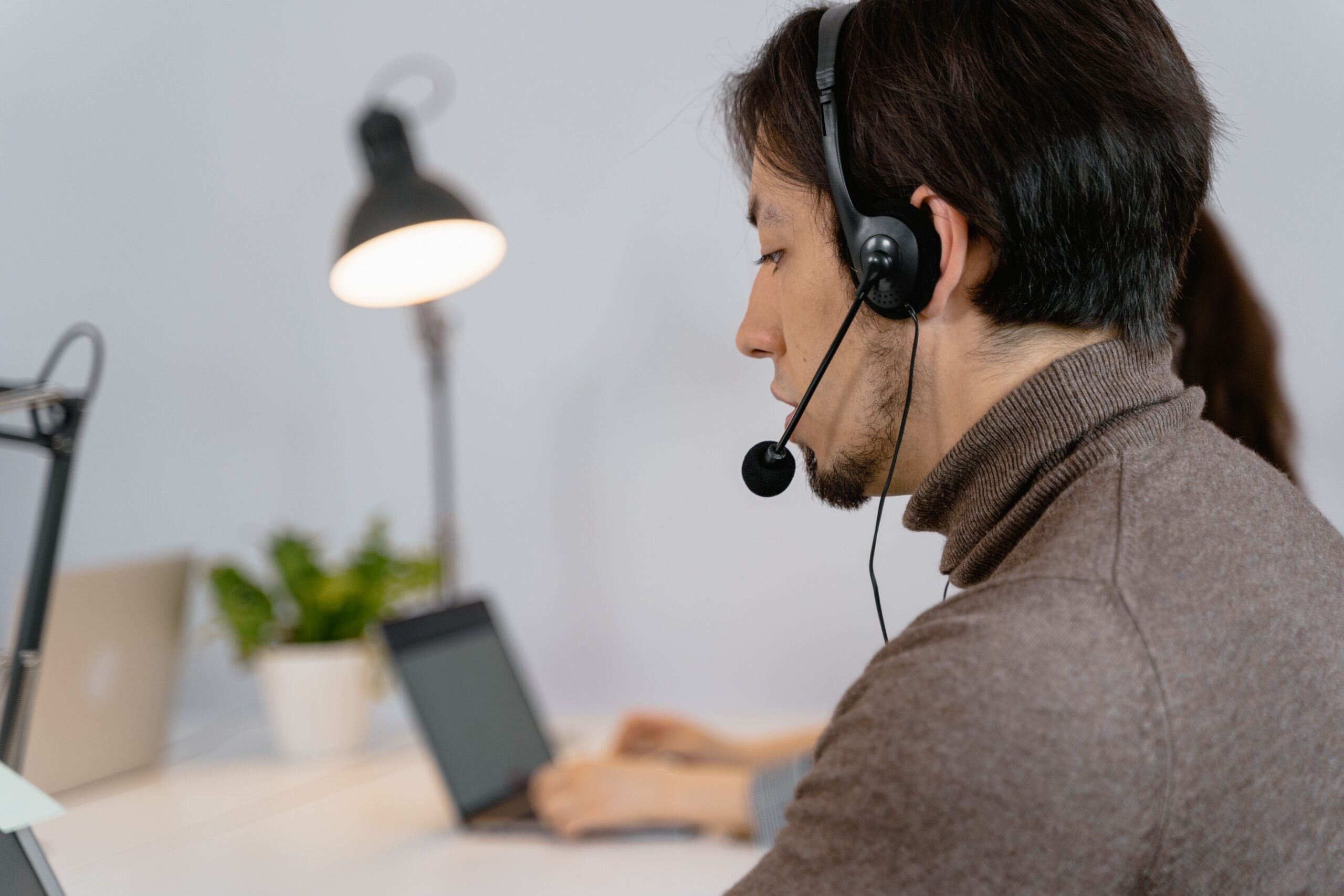 Agente de soporte técnico concentrado utilizando auriculares, destacando la importancia del criterio humano y la empatía en la resolución de incidencias.