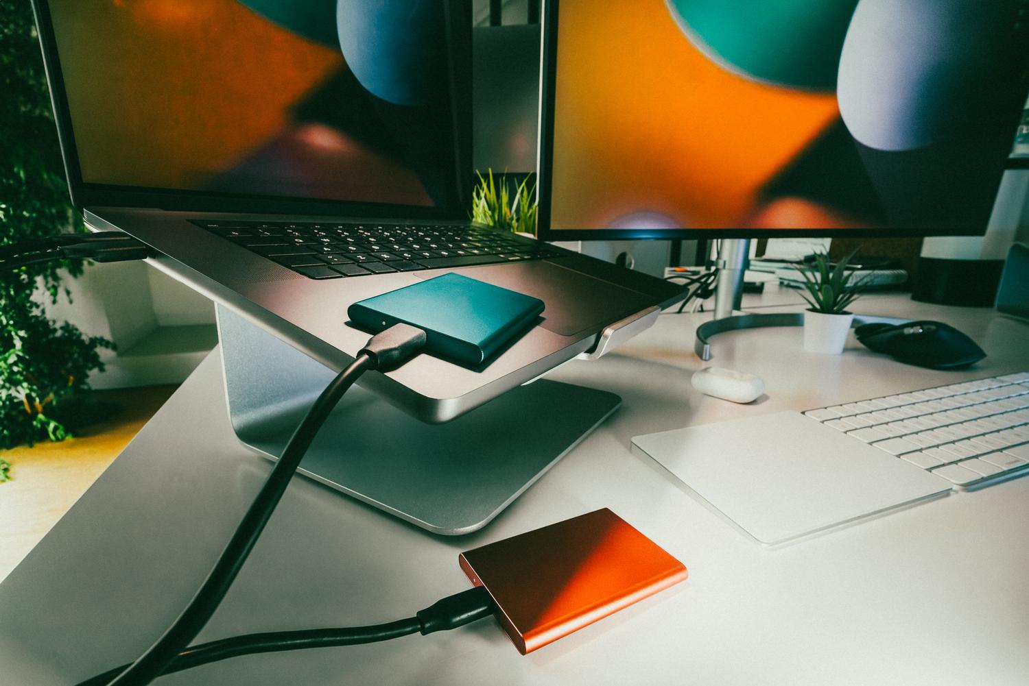 Espacio de trabajo moderno con varios discos duros externos para almacenamiento de datos y copias de seguridad