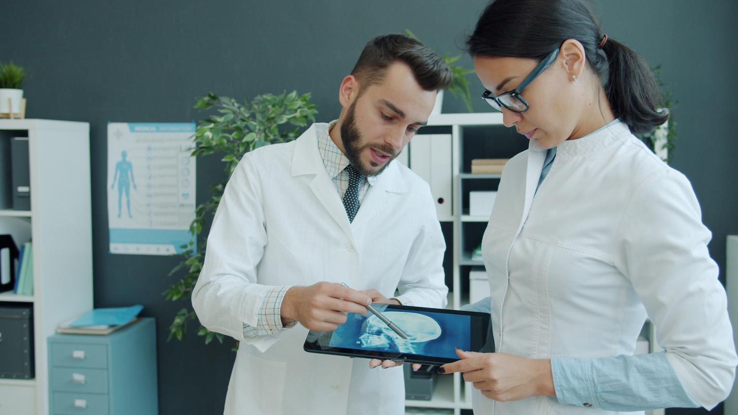 Profesionales sanitarios analizando una imagen médica en una tablet, ejemplificando la aplicación de la IA en la salud digital.