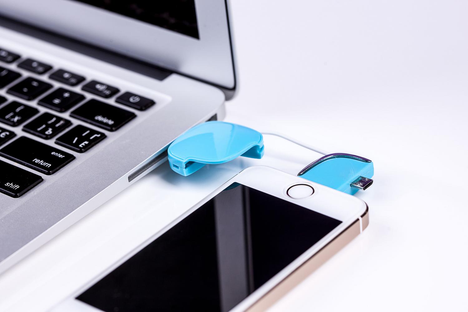 Smartphone conectado a un ordenador portátil mediante un cable USB para recuperación de datos. Smartphone conectado a un ordenador portátil mediante un cable USB para recuperación de datos.