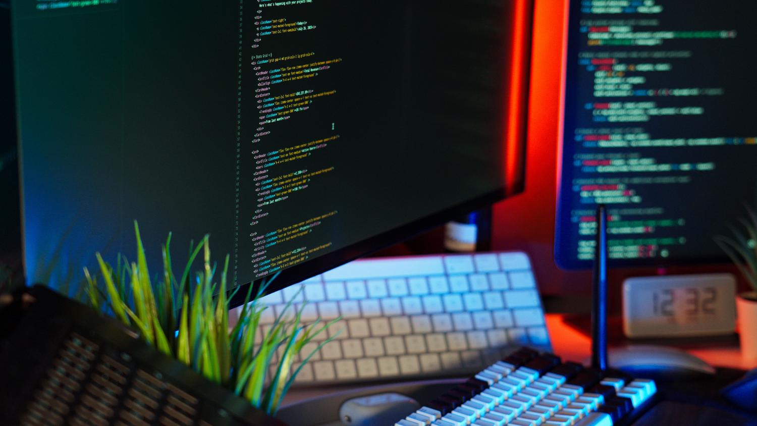 Espacio de trabajo moderno con monitores duales e iluminación contrastada, representando la defensa y el monitoreo de seguridad.