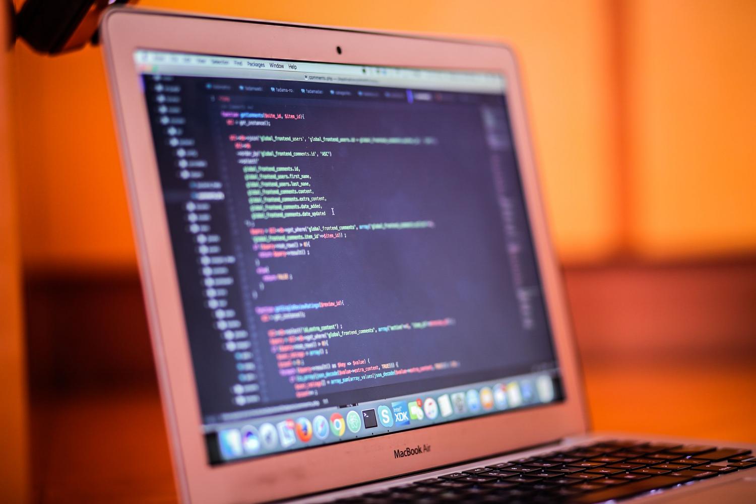 Toma enfocada de un portátil con código fuente, simbolizando la ejecución de scripts personalizados en macOS e iOS.