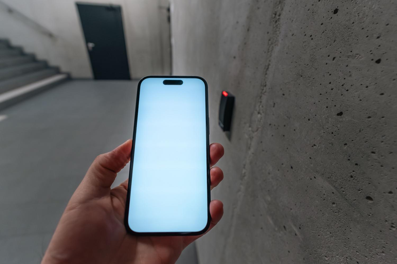 Uso de un smartphone con tecnología NFC para abrir una puerta, ejemplo de automatización avanzada con la app Atajos.