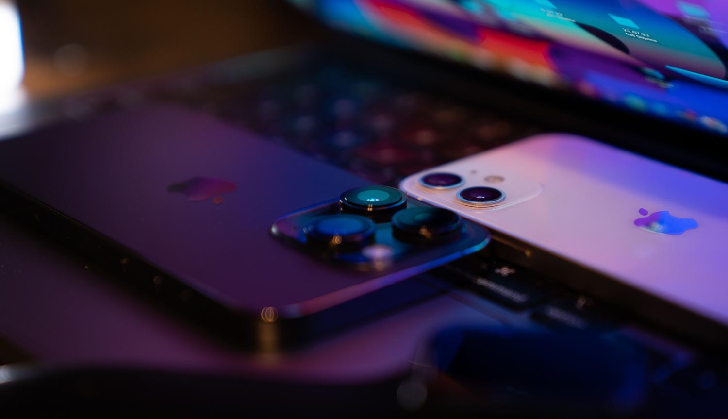 Teléfonos móviles colocados sobre el teclado de un portátil, representando la conexión necesaria para activar el modo de recuperación en iOS o Android.