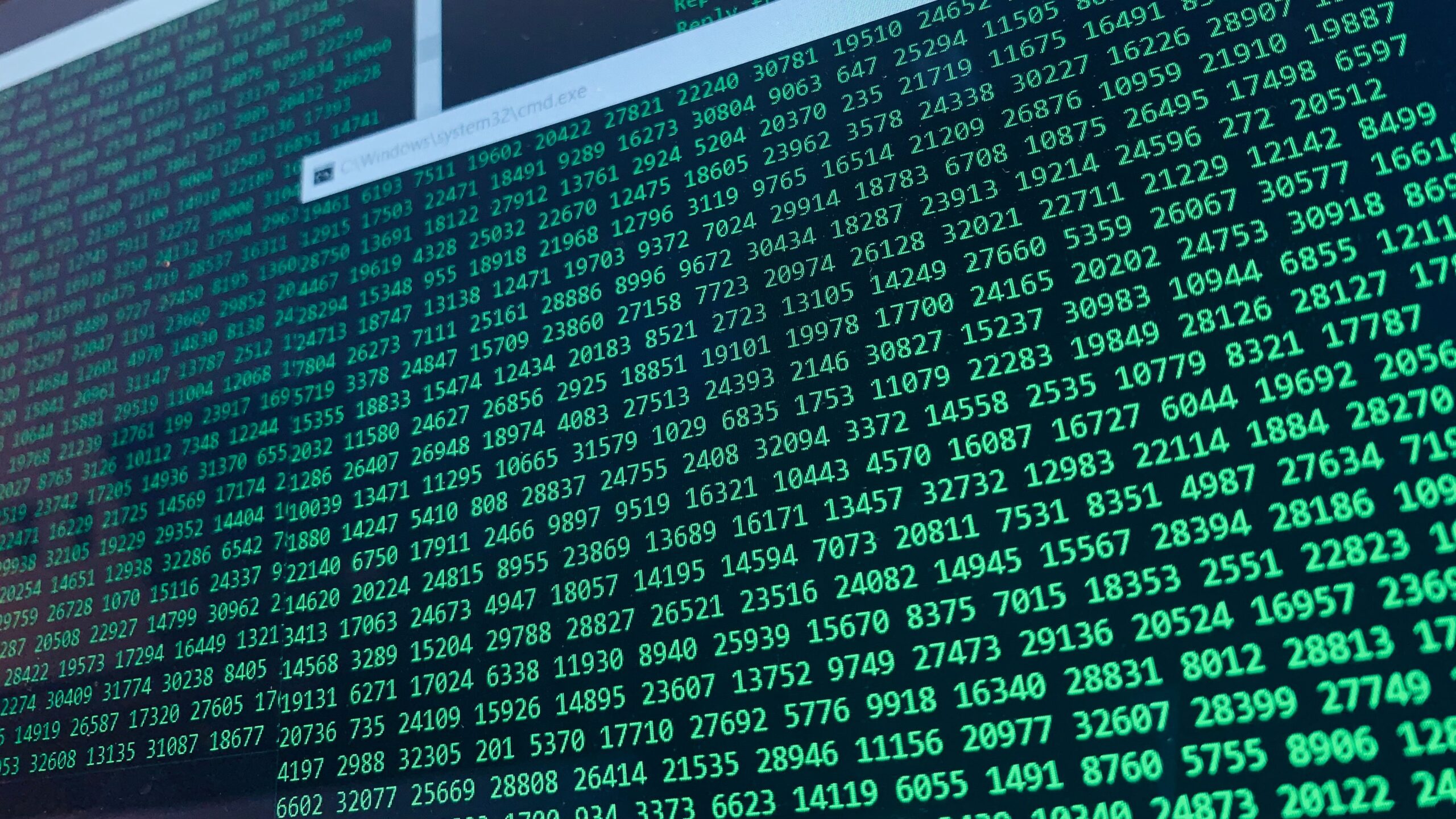 Cascada de números verdes sobre fondo negro en un monitor, representando flujos de datos cifrados y la complejidad de las funciones hash.