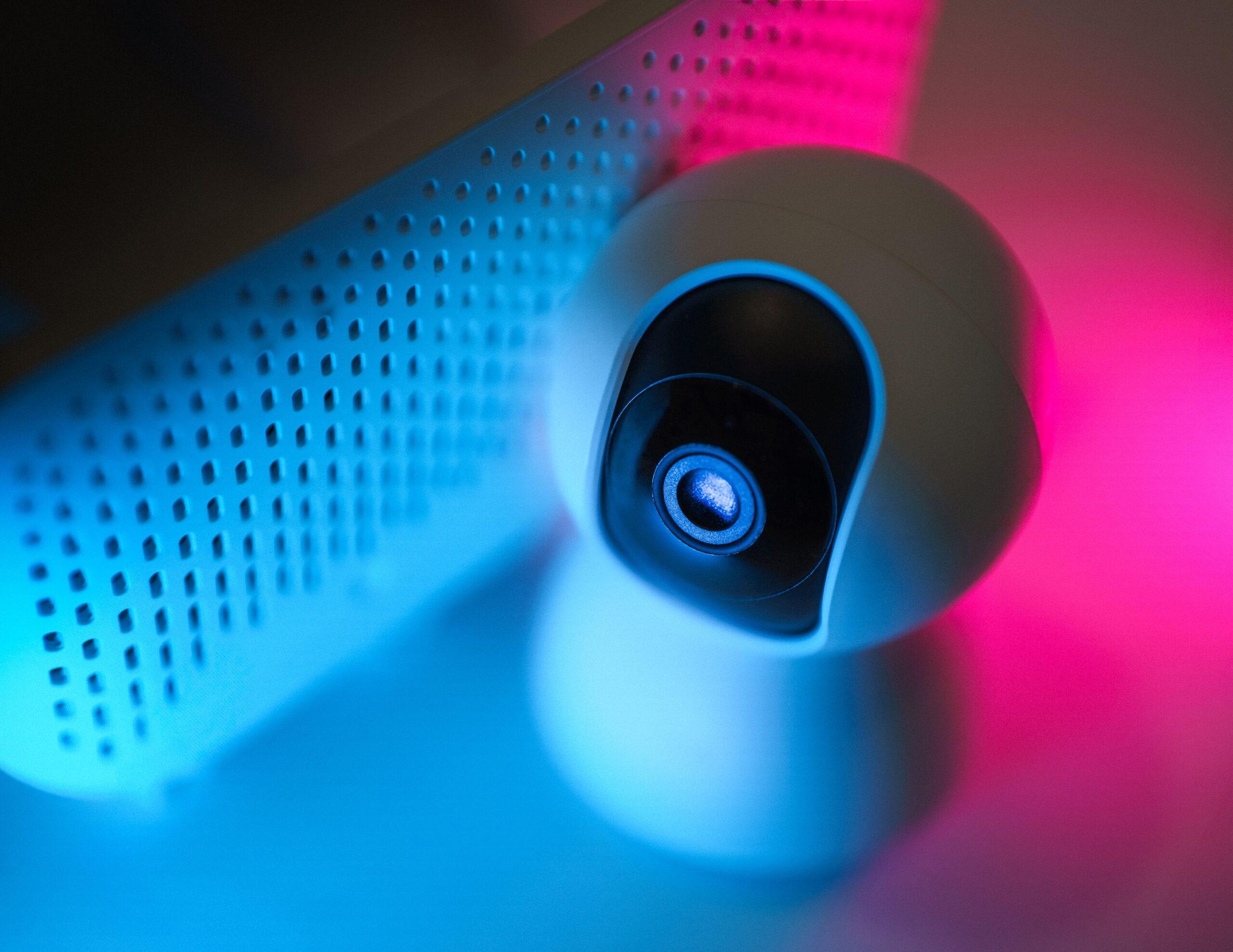 Cámara de seguridad inteligente iluminada con luces neon, representando los dispositivos IoT del hogar.