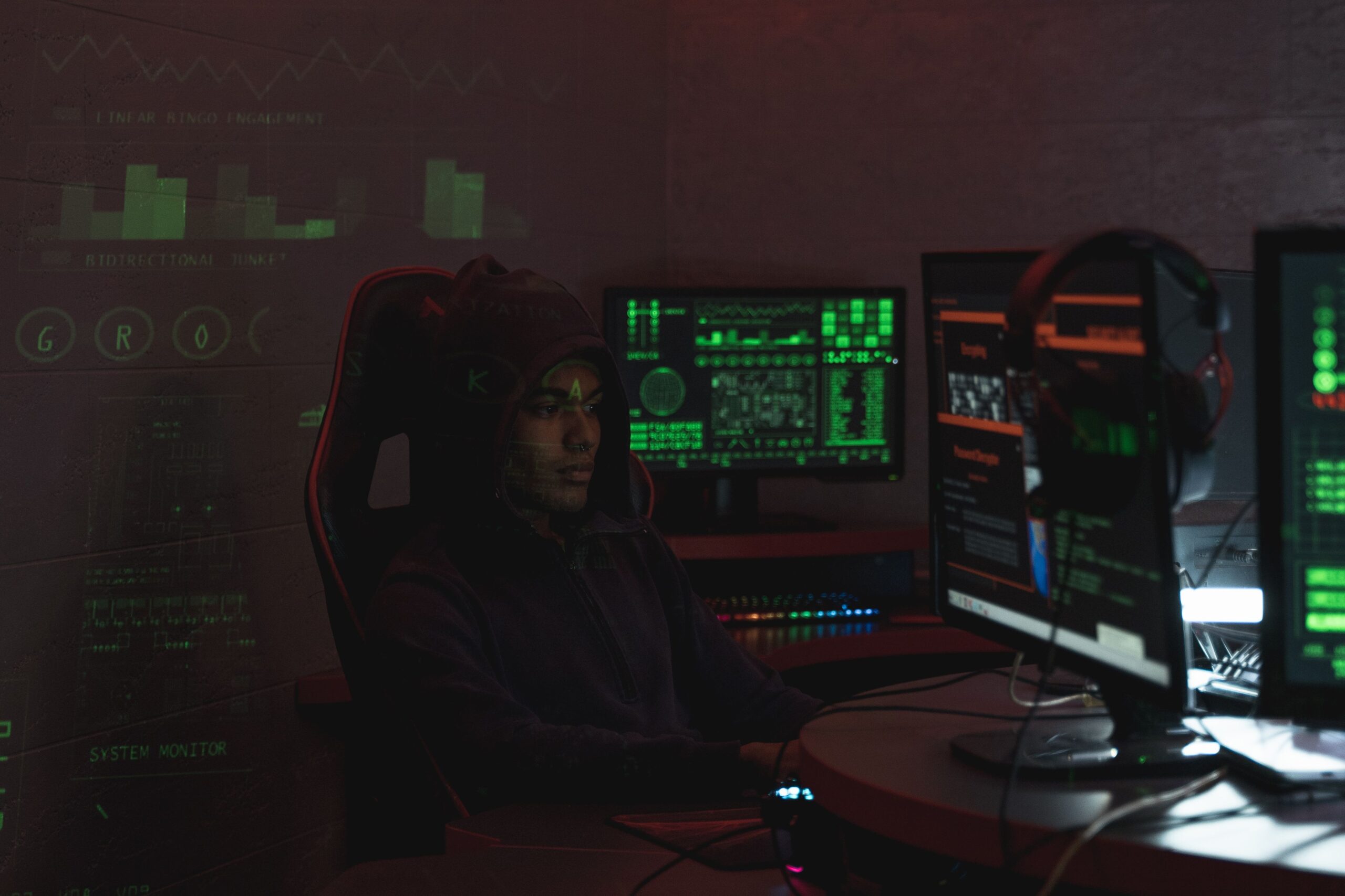 Representación de un ciberdelincuente trabajando en un entorno oscuro con múltiples monitores.