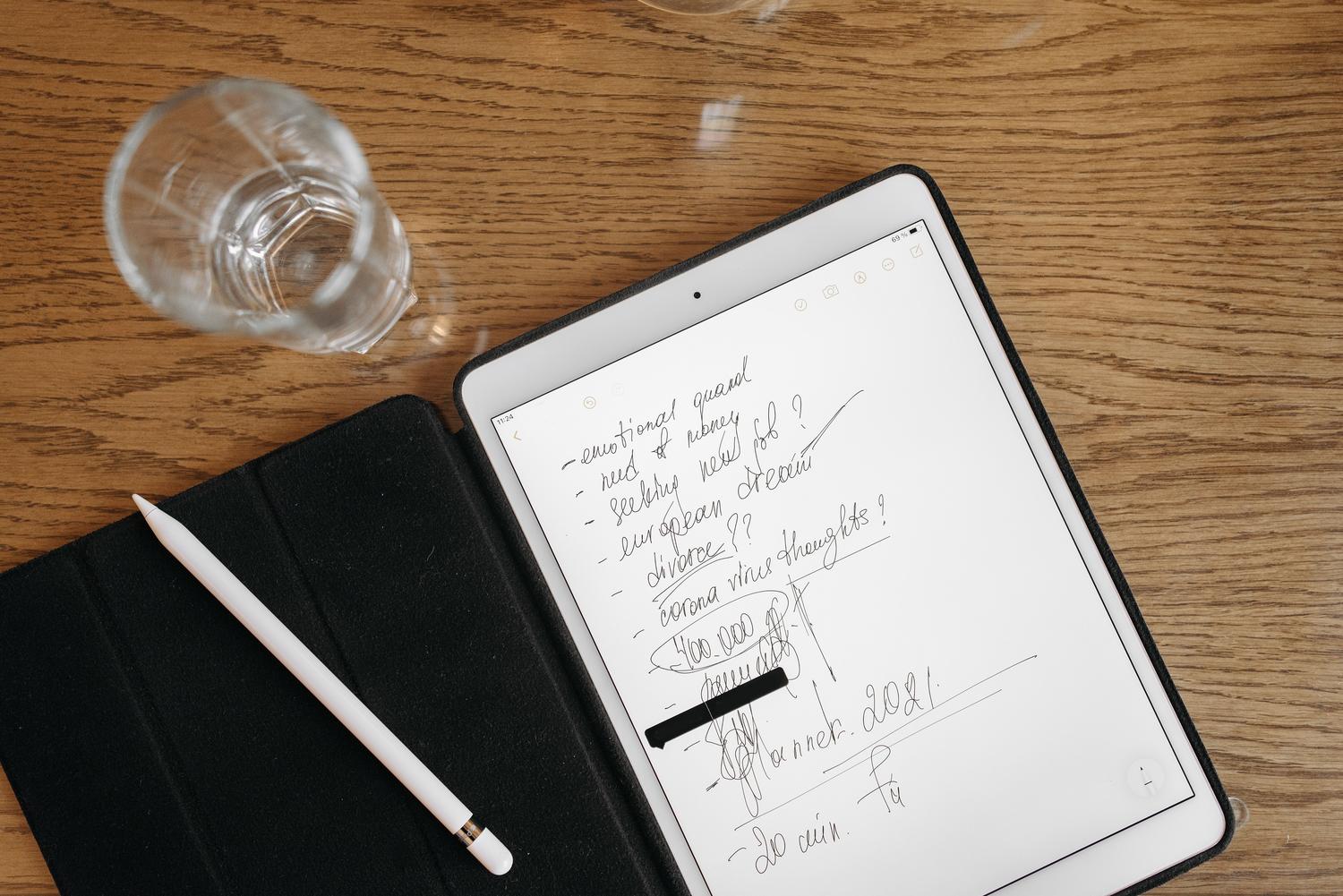 Vista cenital de una tablet con notas escritas a mano y un lápiz digital, simbolizando la implementación de una bóveda digital de conocimiento.