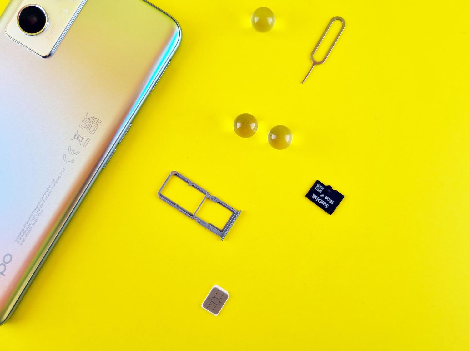 Teléfono móvil con tarjeta SIM y microSD sobre una superficie amarilla vibrante, ilustrando la expansión de memoria de forma moderna.