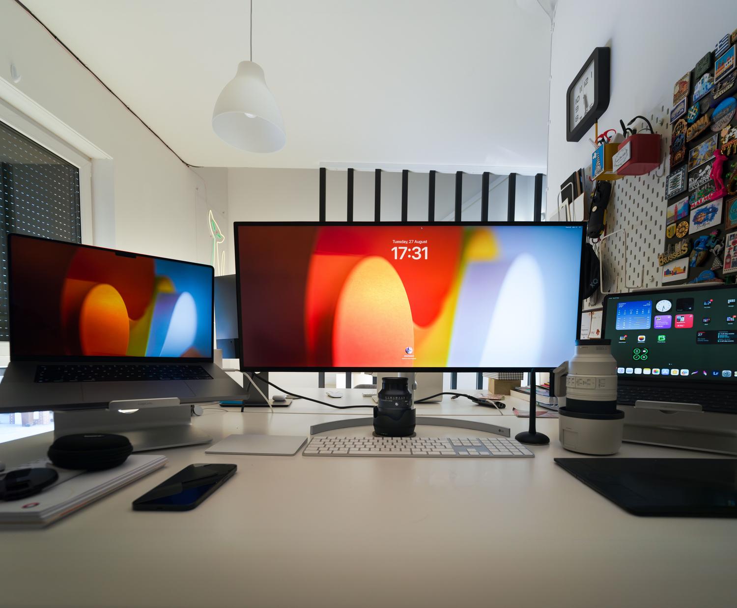Configuración de oficina en casa minimalista y tecnológica con múltiples pantallas, perfecta para la sección de organización personal y vida diaria.