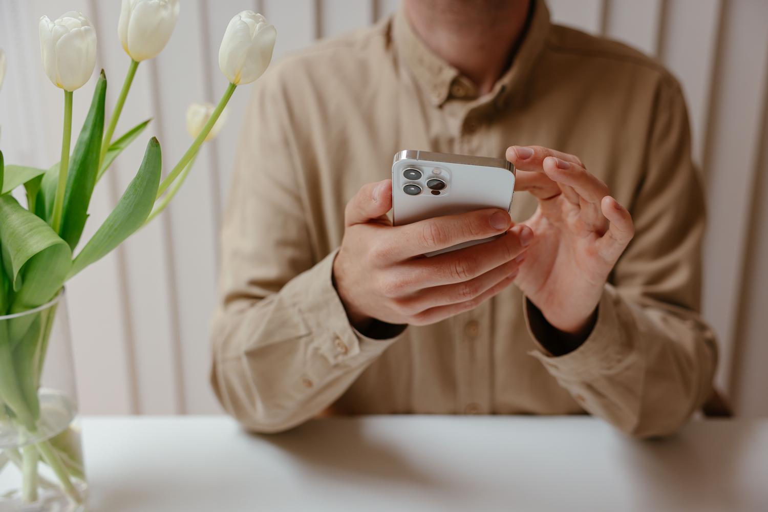 Interacción con un smartphone en un escritorio moderno y minimalista, evocando un entorno de trabajo organizado y productivo.
