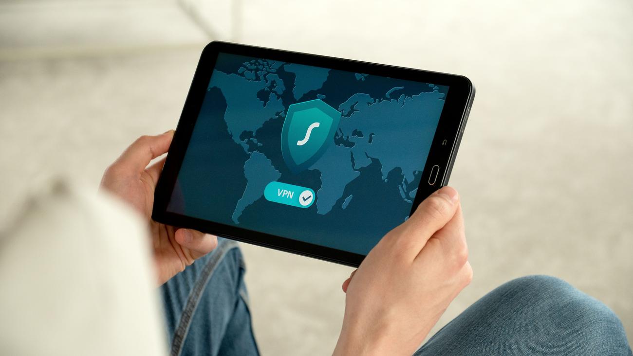Persona utilizando una tablet con una aplicación de VPN activa, ilustrando que el anonimato de red no oculta la huella digital del dispositivo.