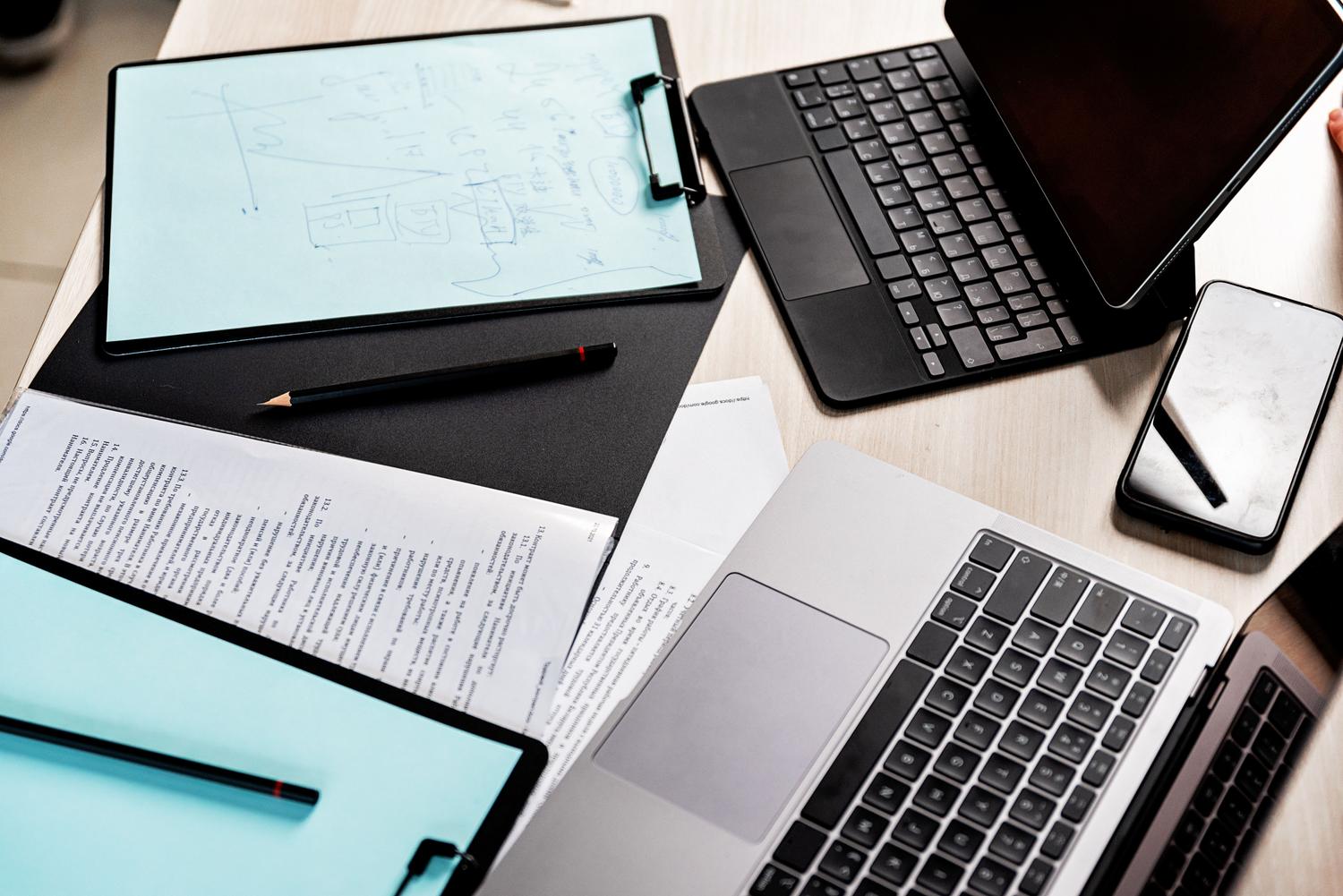 Vista cenital de un espacio de trabajo moderno con tablet, laptop y documentos, representando la gestión de archivos digitales.