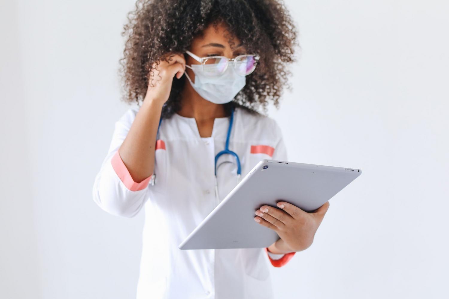 Profesional de la salud interactuando con una tableta digital en un entorno clínico moderno. Profesional de la salud interactuando con una tableta digital en un entorno clínico moderno.