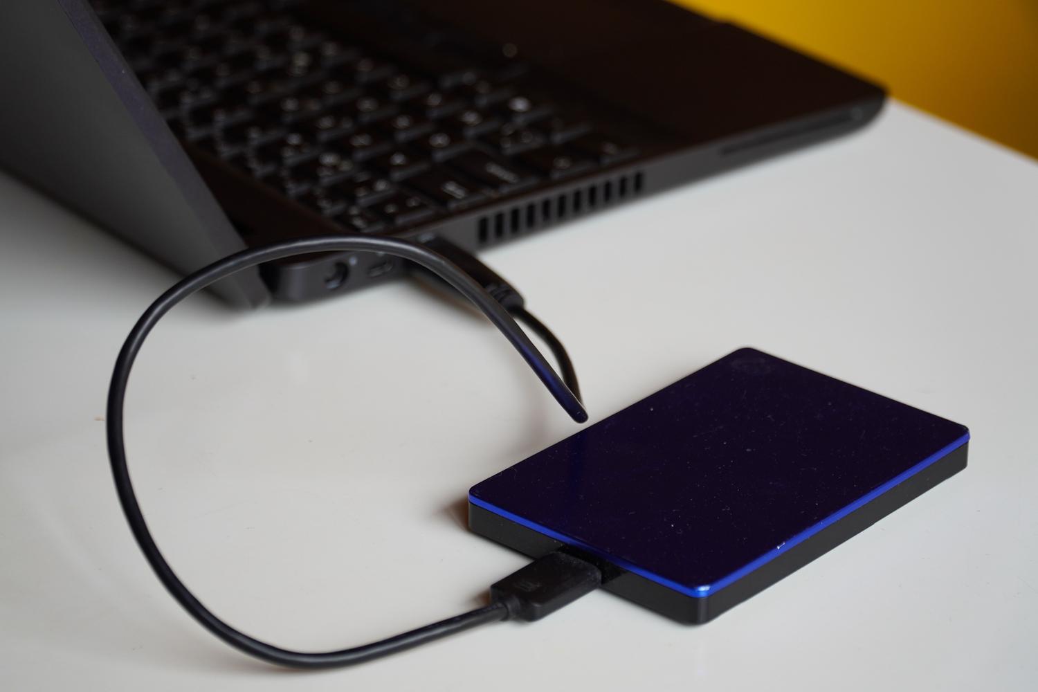 Disco duro externo conectado a un ordenador portátil para realizar una copia de seguridad de los datos