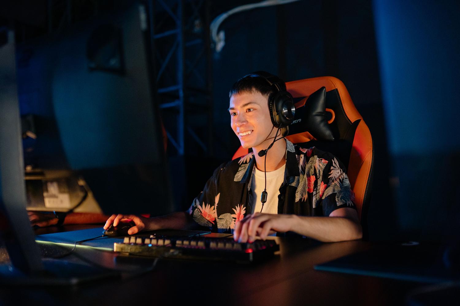Joven gamer sonriendo mientras usa auriculares, capturando la diversión y alegría de jugar con amigos a través de crossplay.