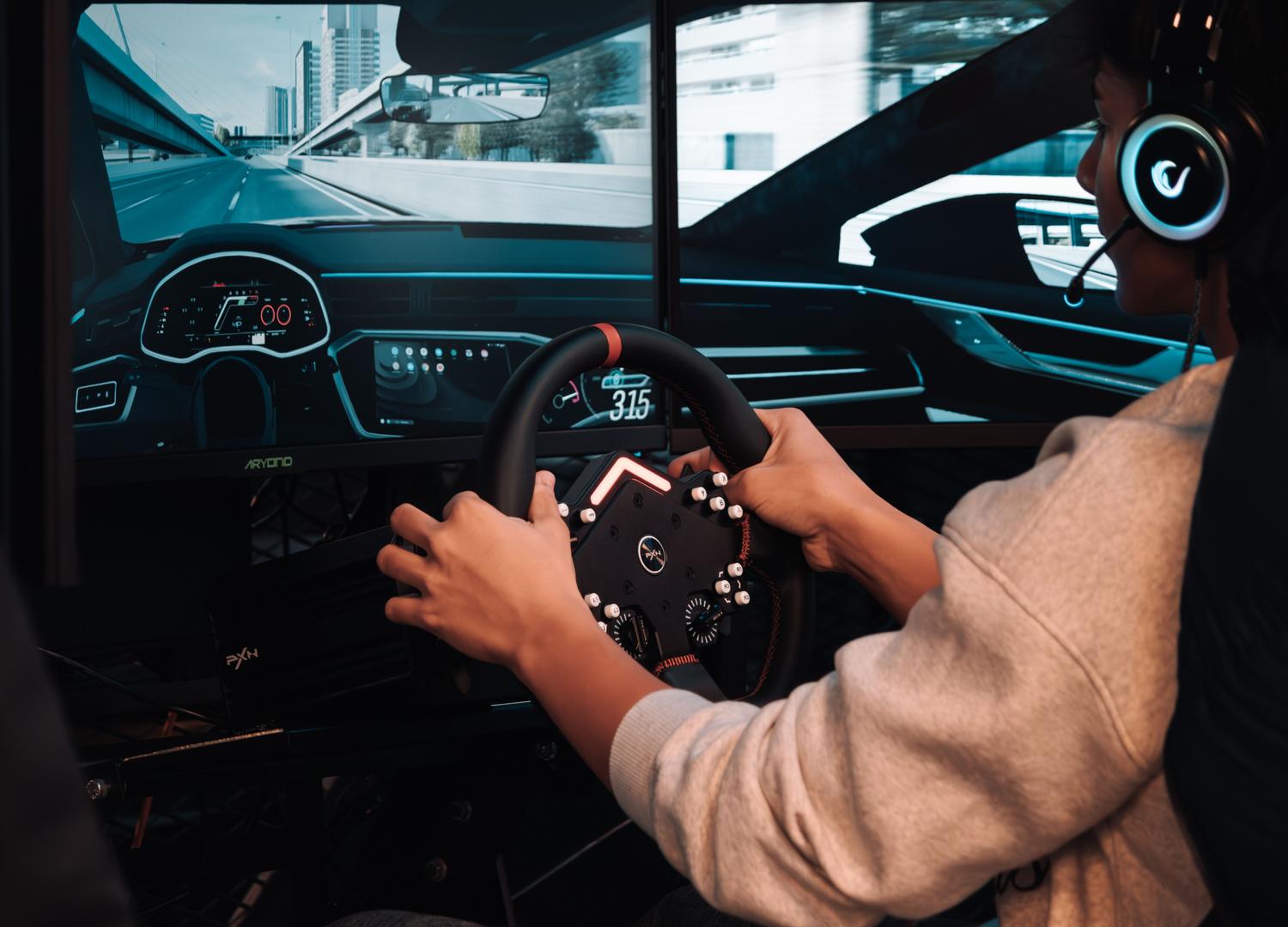 Setup de simracing de alta gama con volante profesional y configuración de múltiples monitores para una inmersión total.
