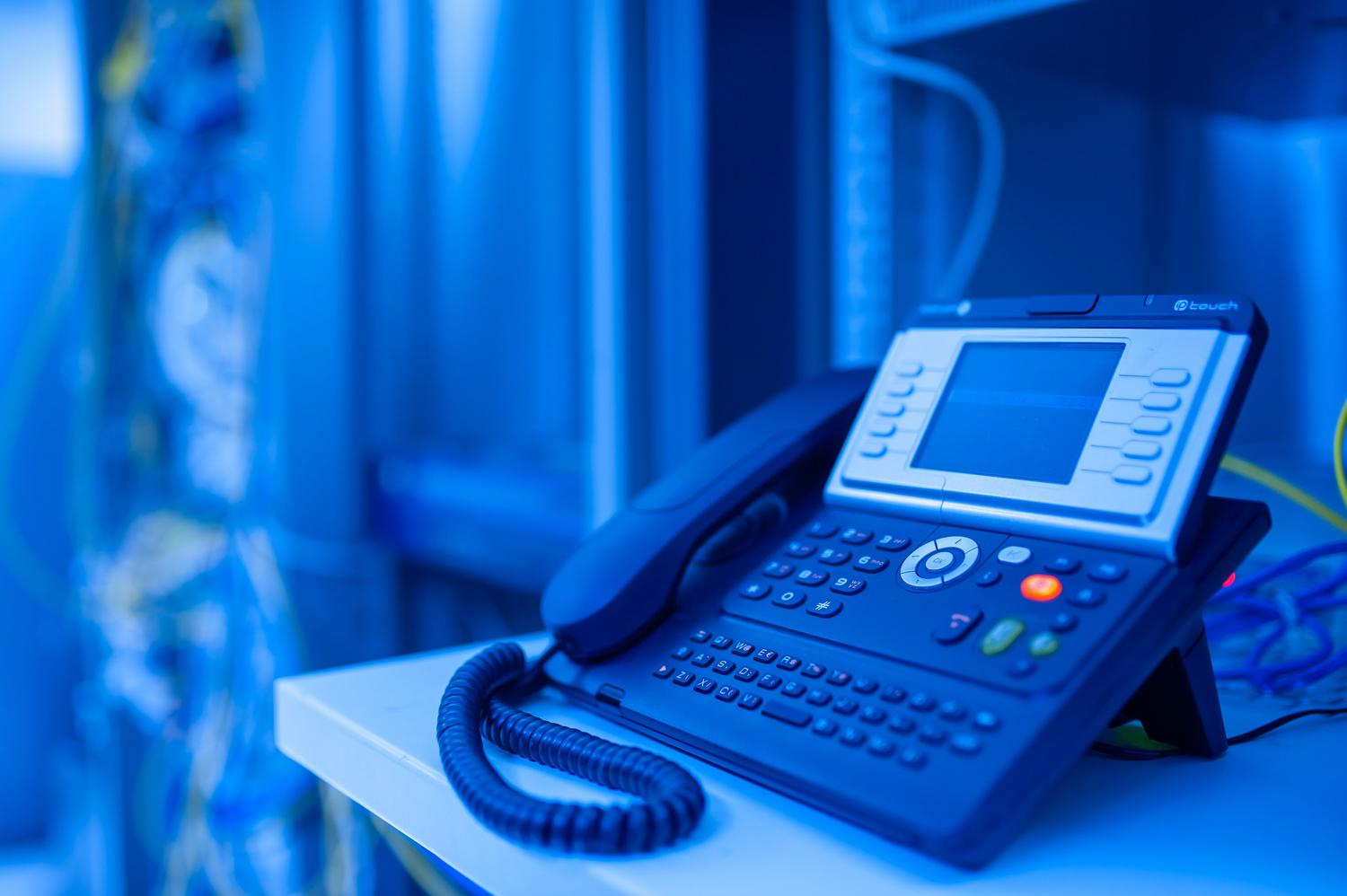 Primer plano de un teléfono IP moderno, símbolo de la tecnología VoIP en el entorno empresarial.