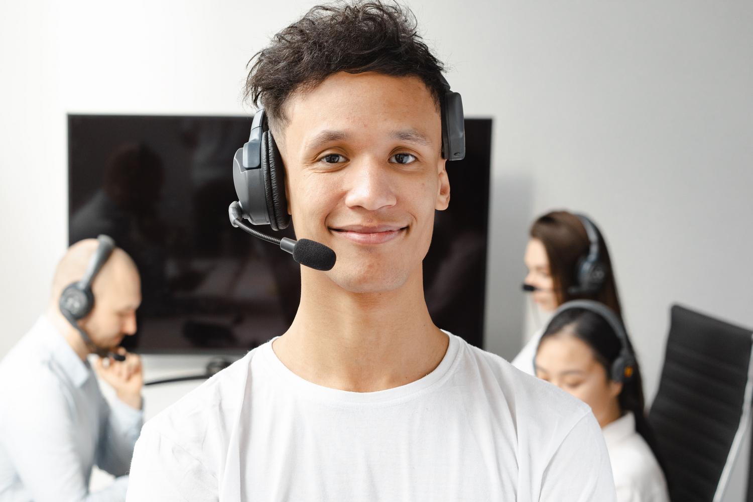 Retrato de un agente de call center profesional y confiado con auriculares en una oficina corporativa.