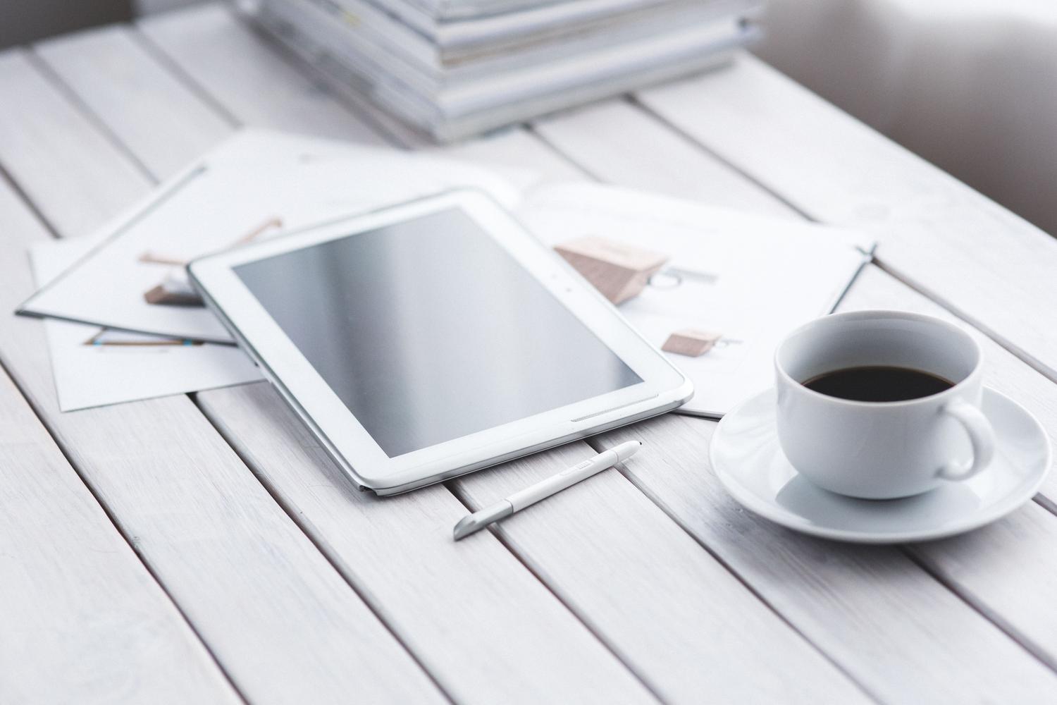 Tablet y lápiz óptico sobre documentos de papel, simbolizando la transición al entorno digital.
