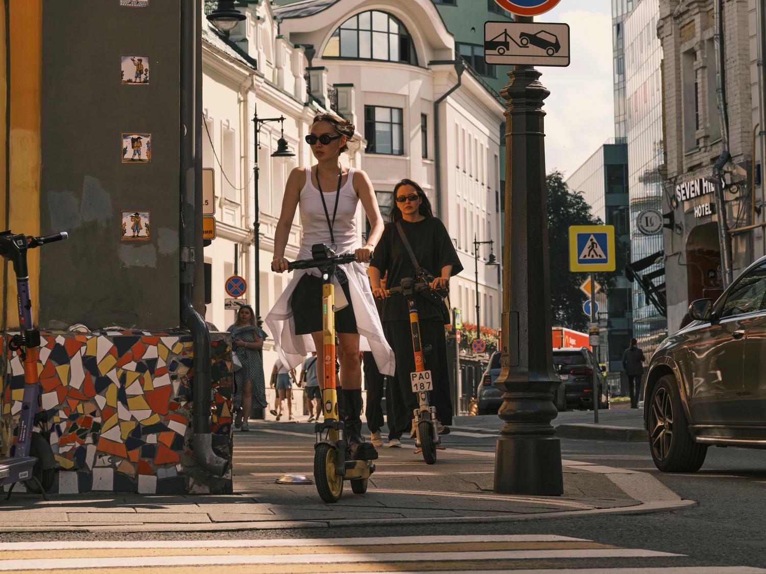 Personas utilizando patinetes eléctricos en la ciudad, una de las aplicaciones reales donde la mayor densidad energética del silicio prolonga la autonomía.