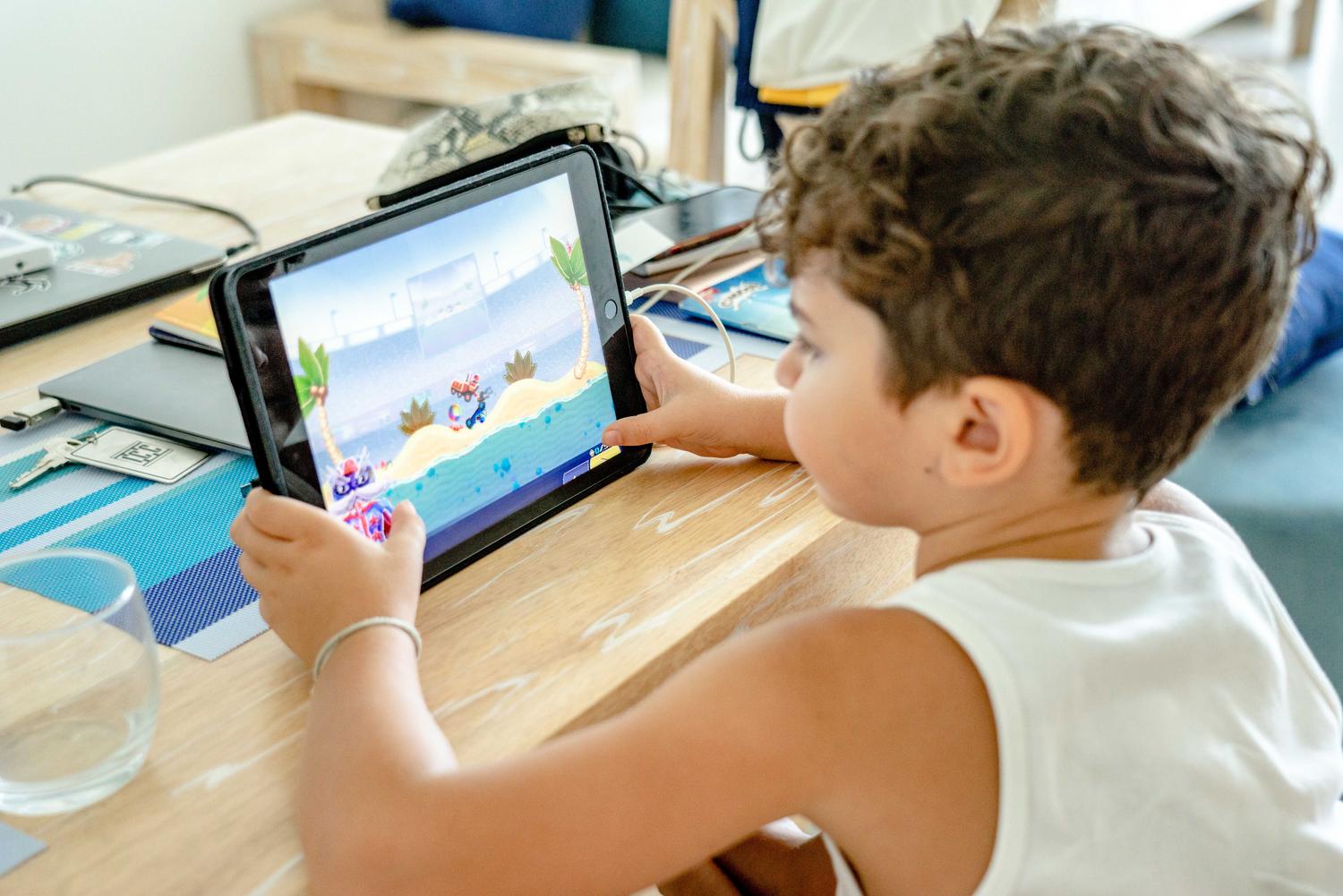 Niño jugando a un videojuego colorido en una tablet, representando el rendimiento gaming del procesador UNISOC T618.