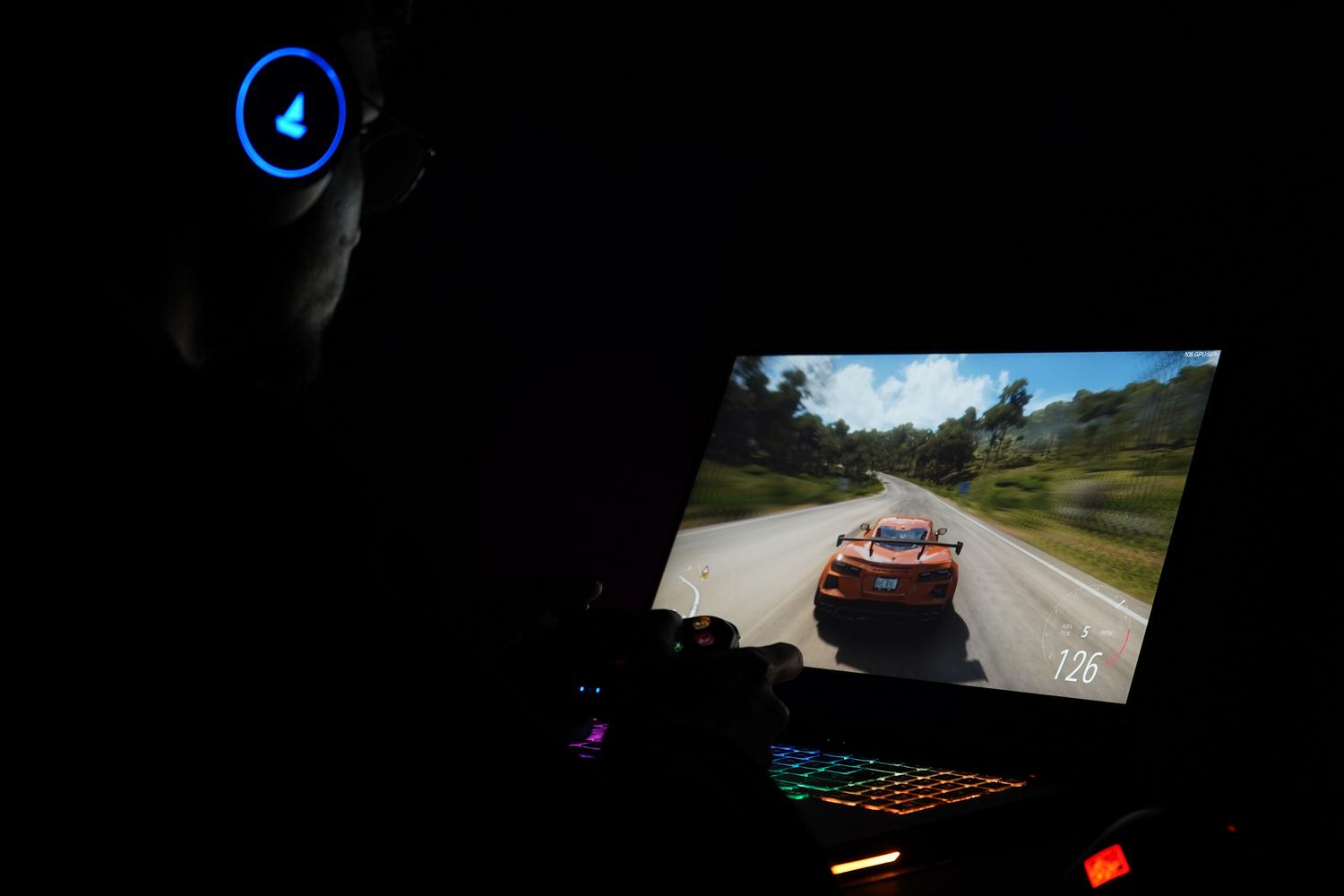 Persona jugando a un videojuego de carreras en un portátil con auriculares, representando la capacidad de gaming del chip AMD Ryzen 7 5825U.