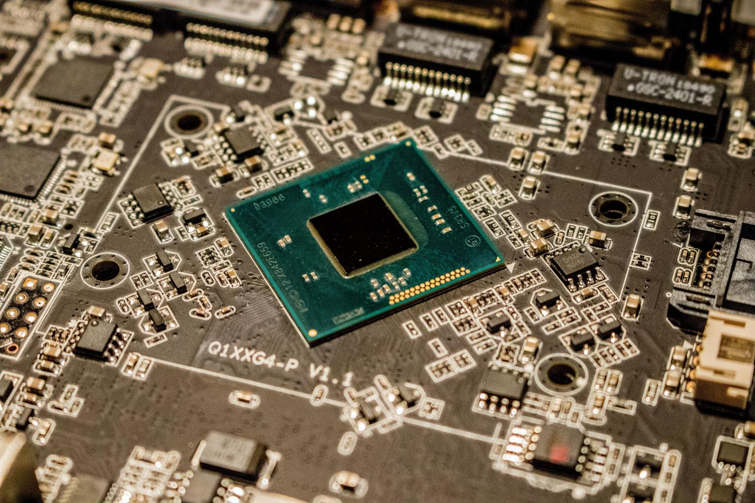 Fotografía macro de un microchip integrado en una placa de circuito impreso con trazas electrónicas.