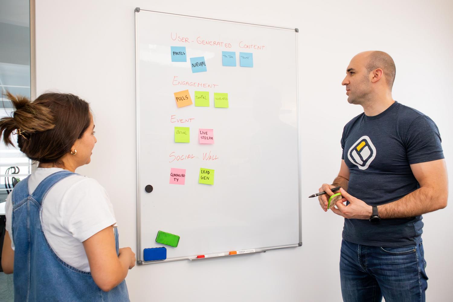 Equipo de trabajo realizando una sesión de brainstorming frente a una pizarra blanca para definir el propósito de un agente de IA.