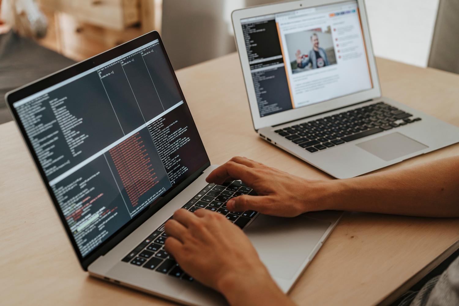 Programador trabajando en el desarrollo de código en un ordenador portátil, representando la elección del stack tecnológico.