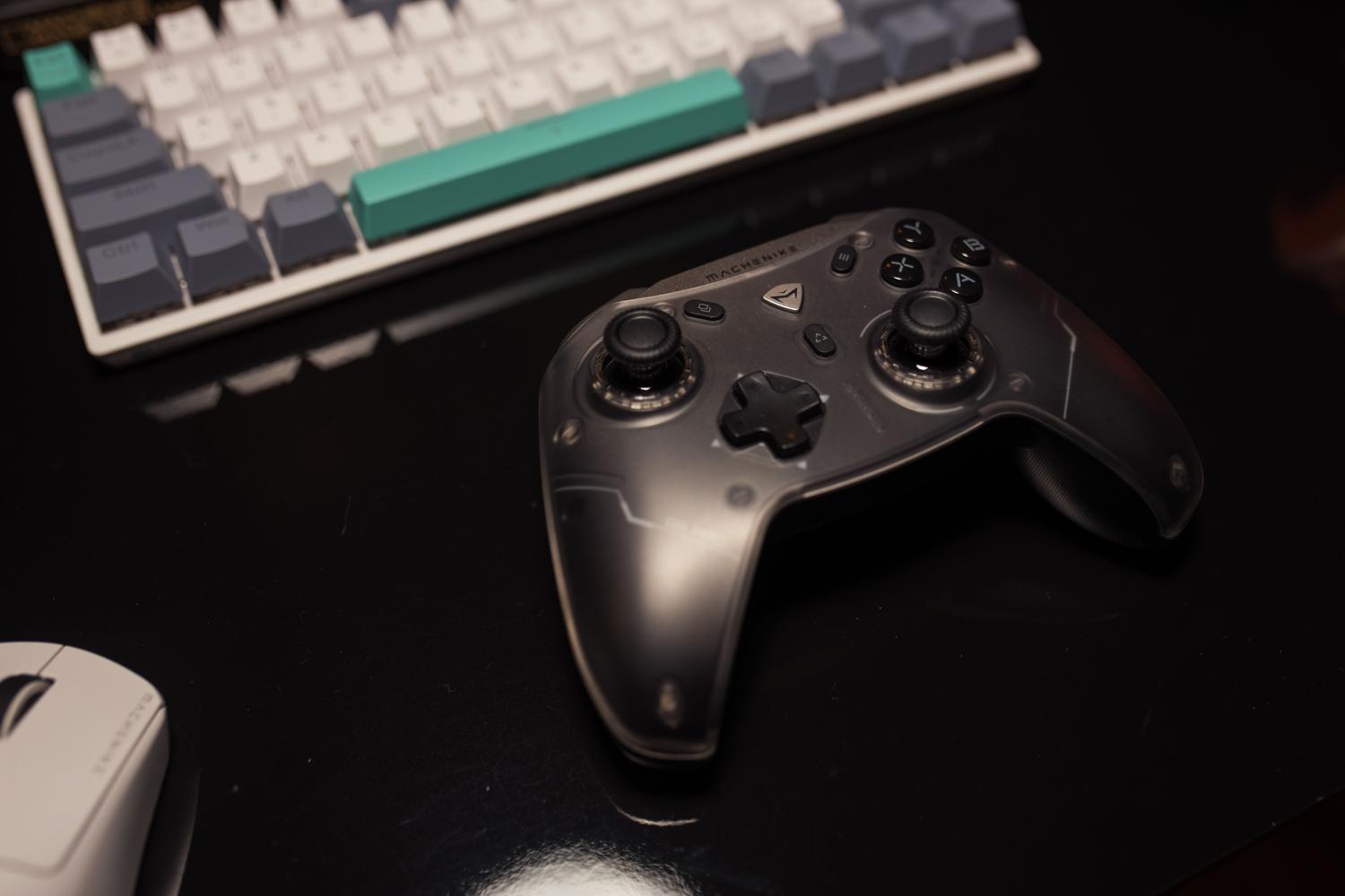 Mando de videojuegos sobre un escritorio junto a un teclado y ratón gamer.