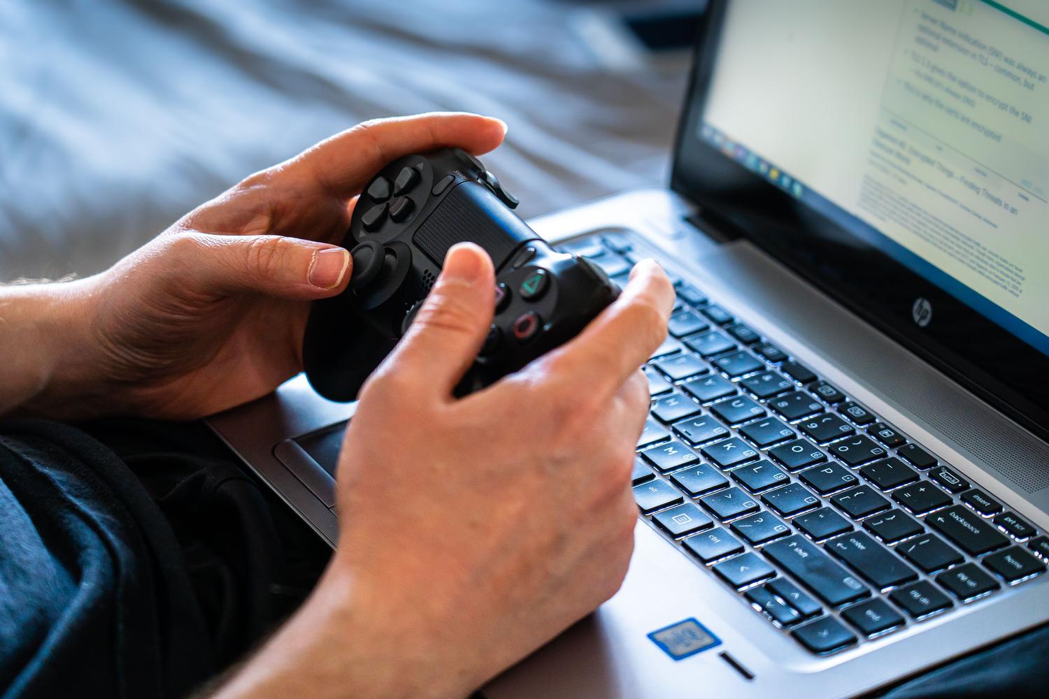 Persona utilizando un mando de videojuegos junto a un ordenador portátil para configurar la conexión.