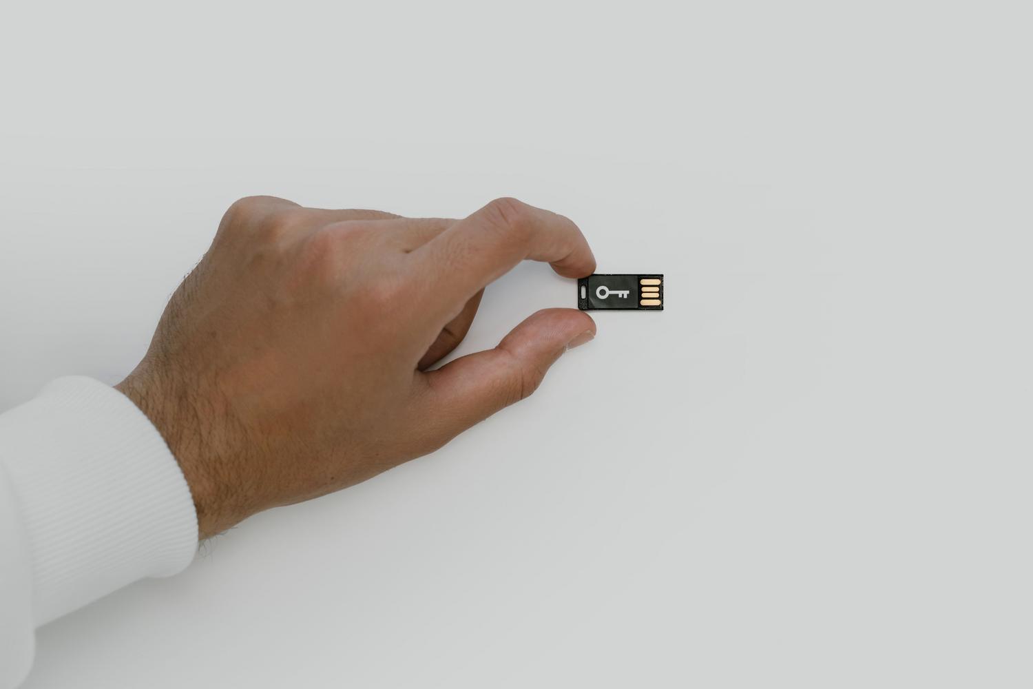 Memoria flash USB con un icono de llave, ilustrando el cifrado de datos y la seguridad informática.