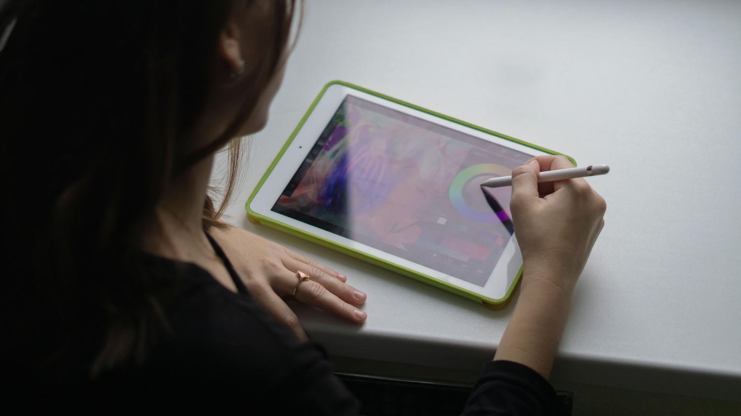 Un profesional utilizando un lápiz digital en una tableta para crear arte, mostrando cómo pointermove rastrea las coordenadas en tiempo real.