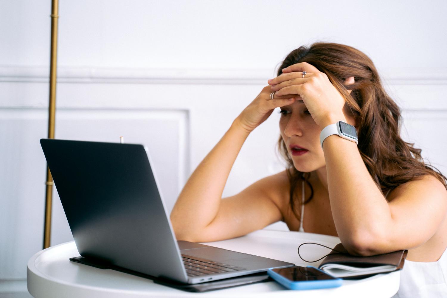 Mujer frustrada frente a un ordenador portátil ilustrando los problemas de conexión a internet