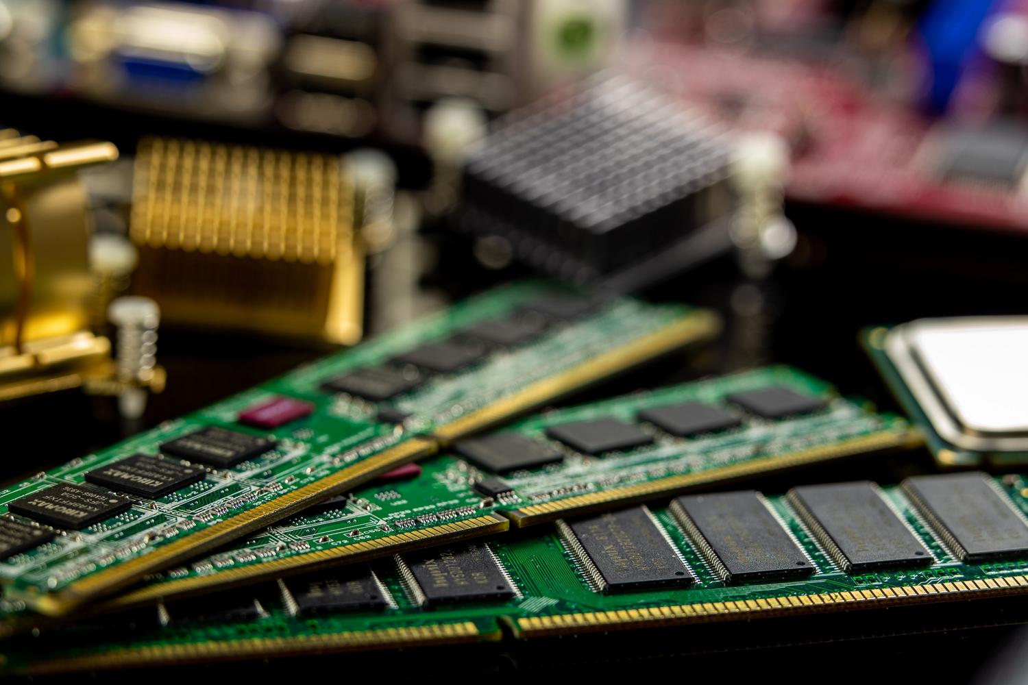 Primer plano detallado de módulos de memoria RAM y microprocesadores en una placa base, ilustrando las especificaciones técnicas de hardware.
