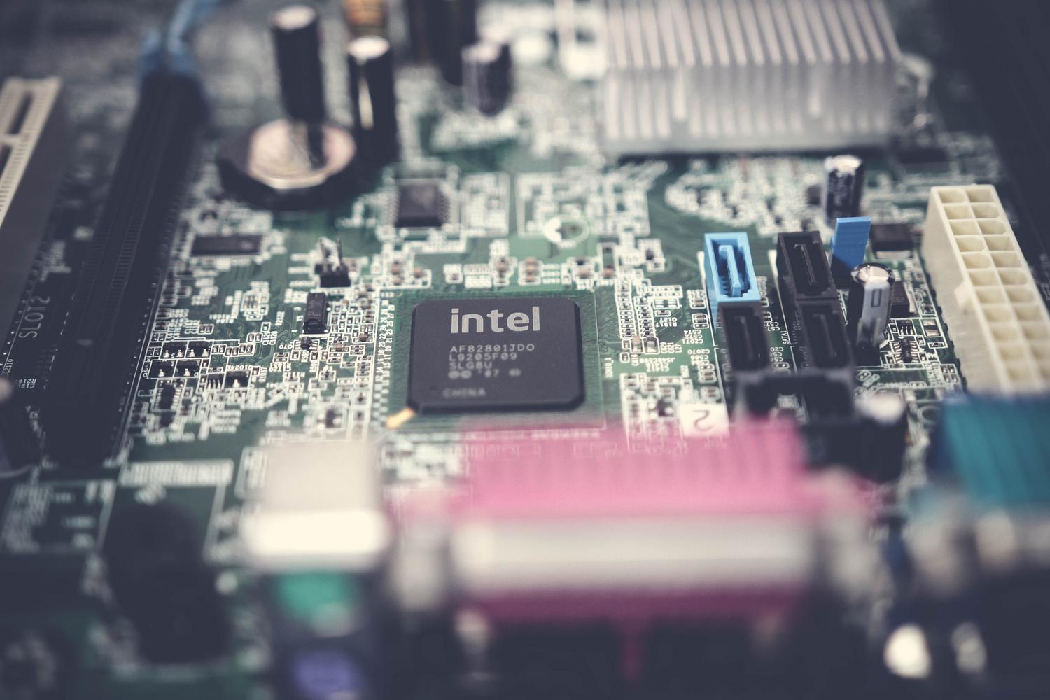 Primer plano detallado de una placa base de ordenador, representando los componentes técnicos y requisitos de hardware