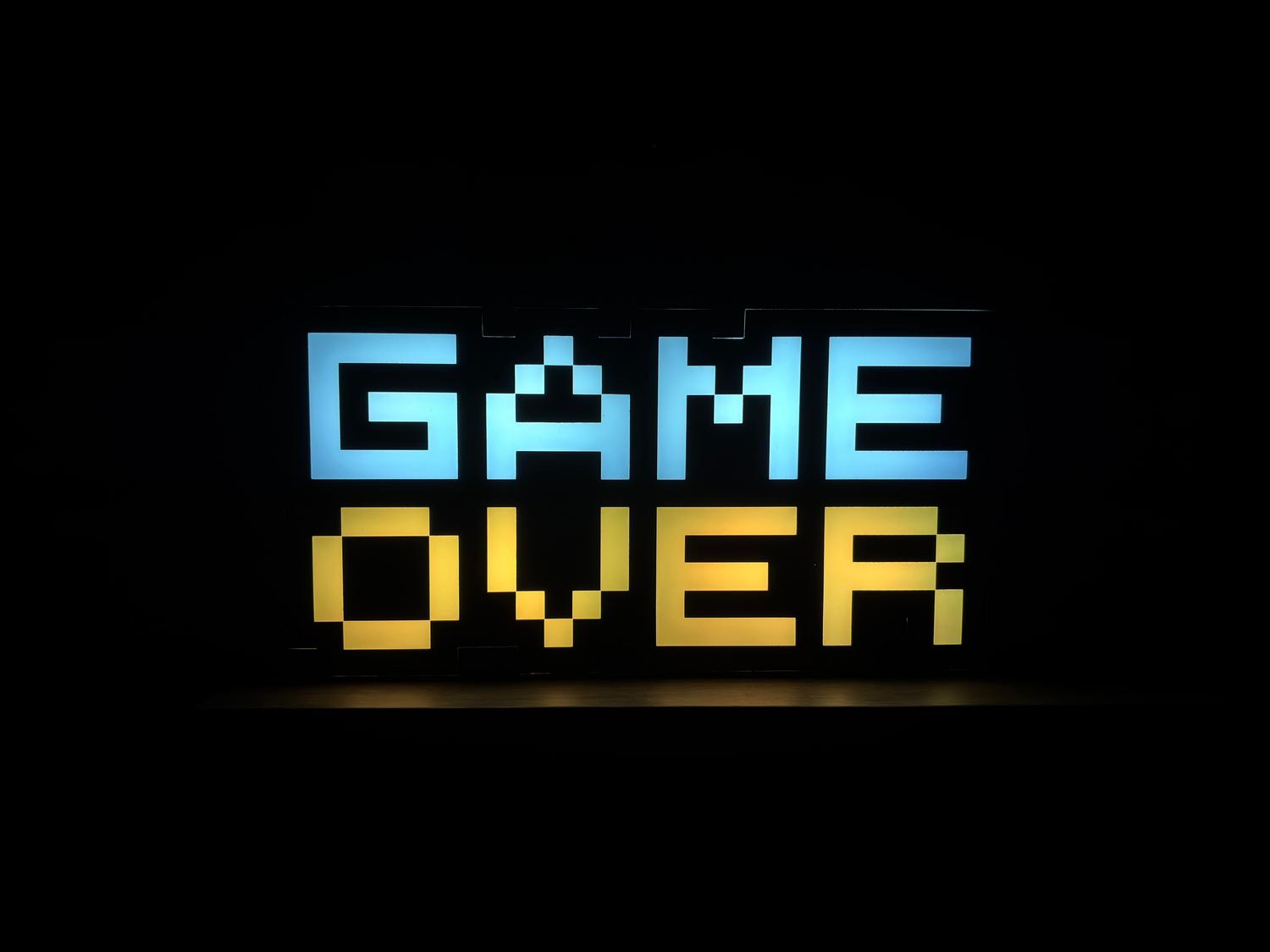 Letrero de neón con la frase 'Game Over' en estilo pixel art sobre un fondo oscuro.