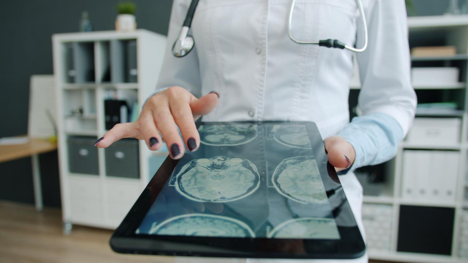 Médica profesional analizando datos clínicos en una tablet, simbolizando el rigor científico, la formación acreditada y el vínculo médico-paciente real.