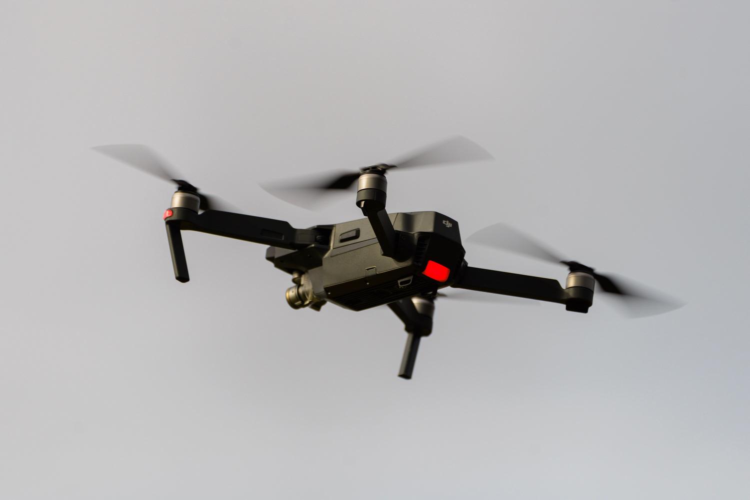 Un dron cuadricóptero moderno volando en el aire, representando la tecnología de captura de datos para fotogrametría.