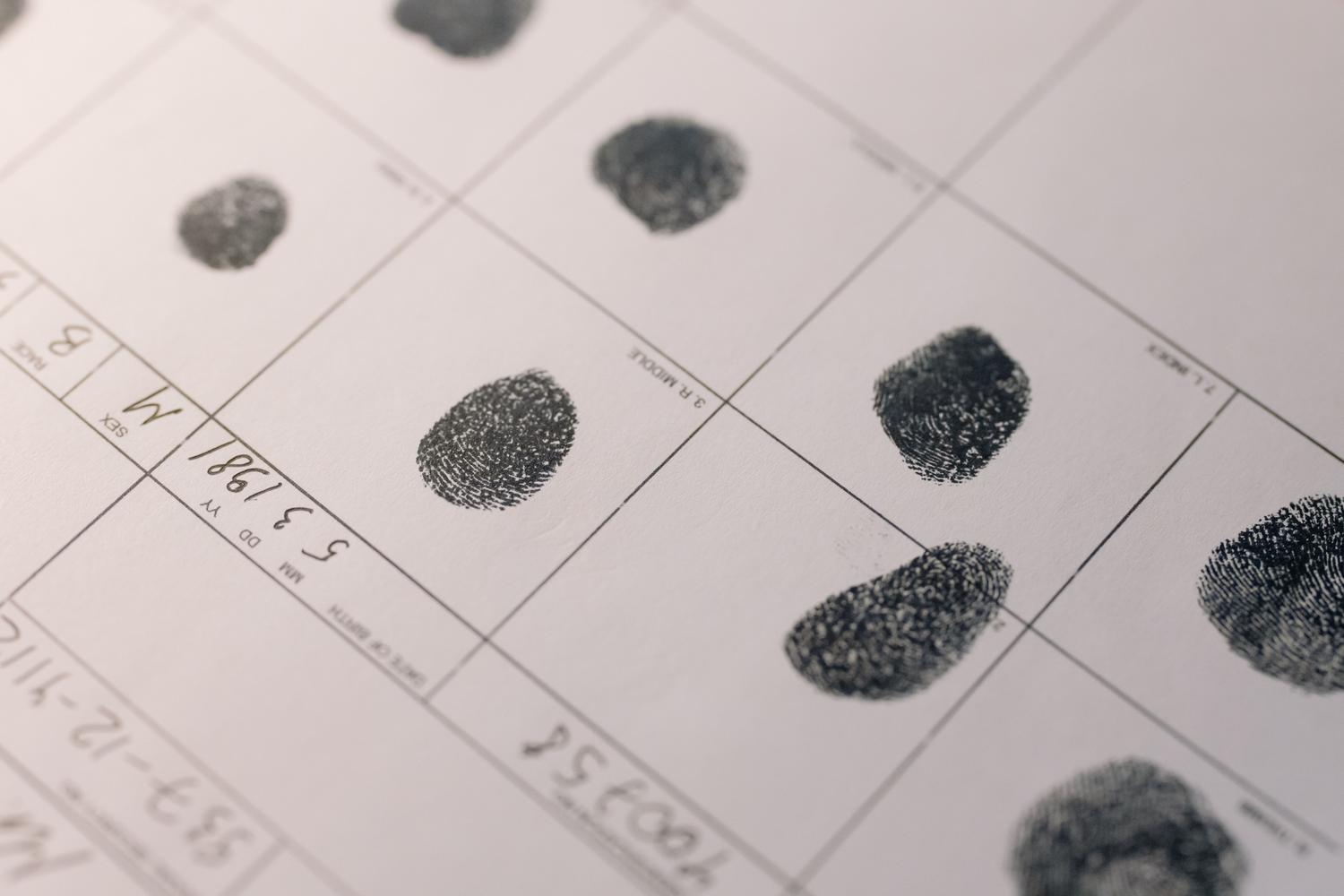 Primer plano de un documento oficial con huellas dactilares, representando los métodos tradicionales de verificación de edad mediante documentos de identidad.