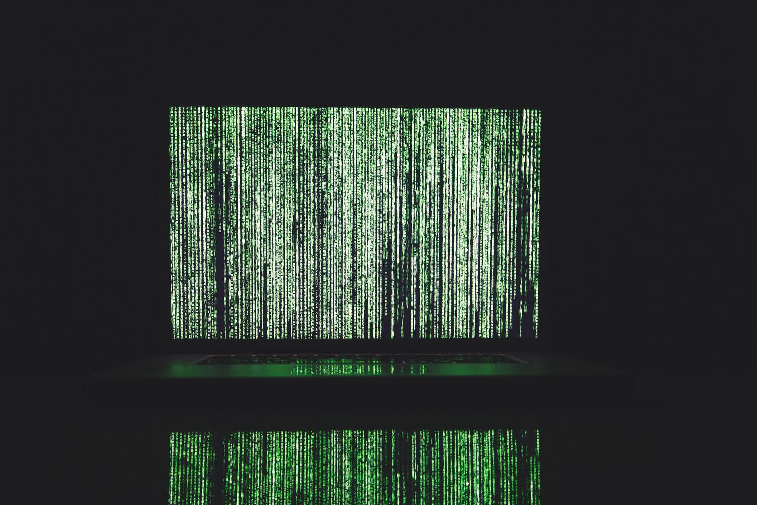 Representación abstracta de código digital estilo matrix en un monitor, evocando la vulnerabilidad del sistema.