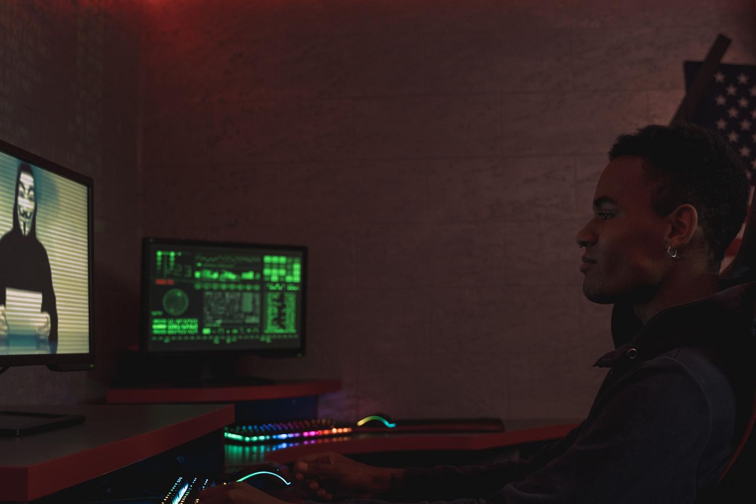 Profesional de ciberseguridad monitorizando sistemas de datos en un entorno oscuro.