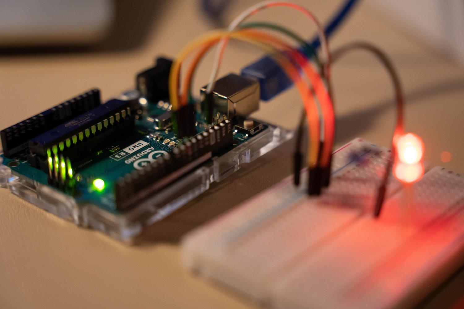 Microcontrolador Arduino conectado a una placa de pruebas con un LED encendido