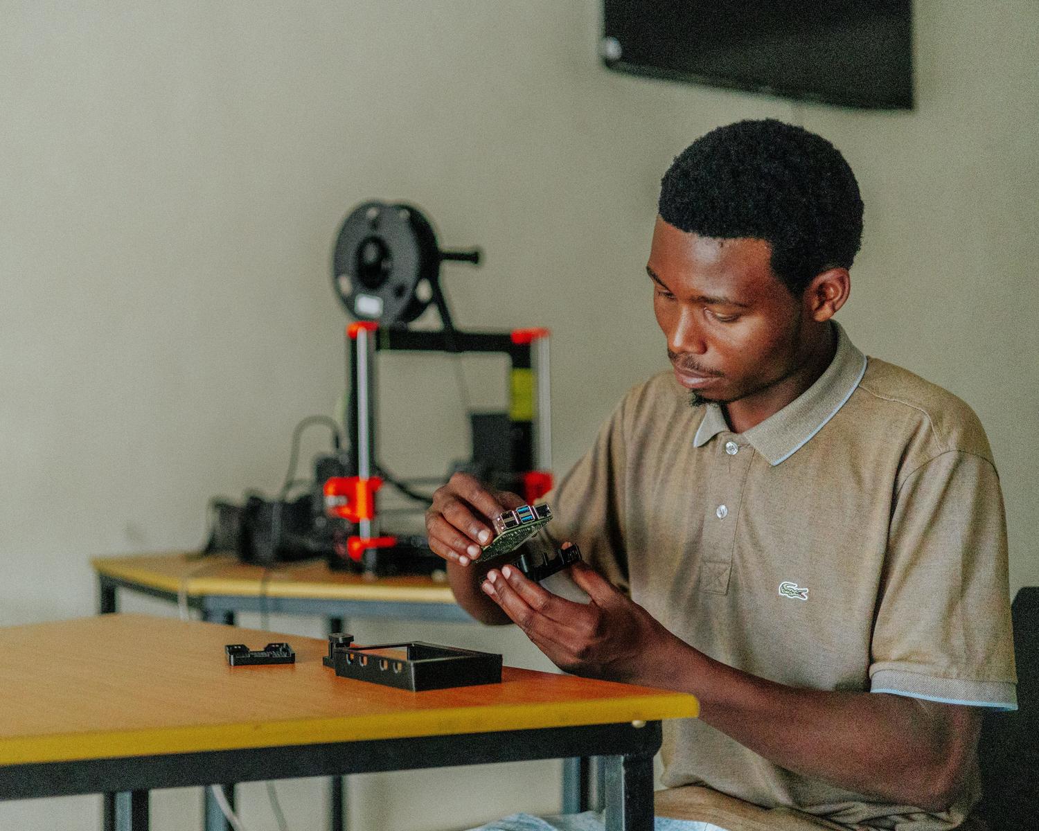 Joven entusiasta de la tecnología montando un circuito electrónico en su mesa de trabajo